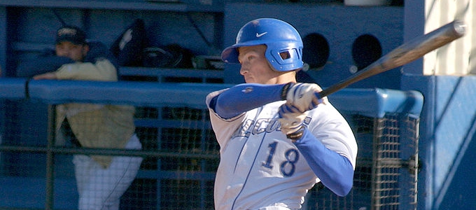 baseball player in a white and blue uniform with the number 18 swinging a bat